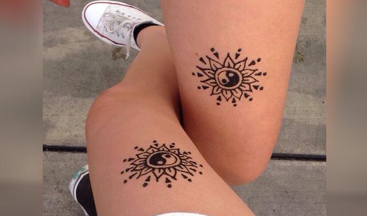 tatuagem de henna estilo indiano com o desenho dos símbolos de yin e Yang na coxa de duas pessoas diferentes