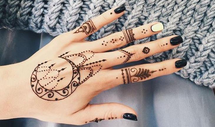 tatuagem henna estilo indiano nos dedos e uma lua na mão