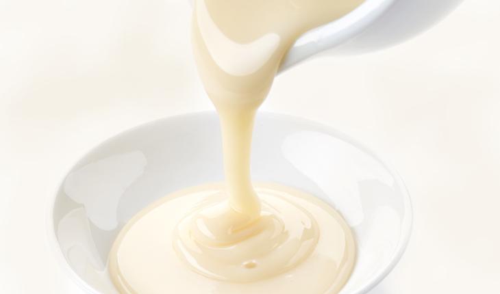 leite condensado sendo despejado em uma travessa branca
