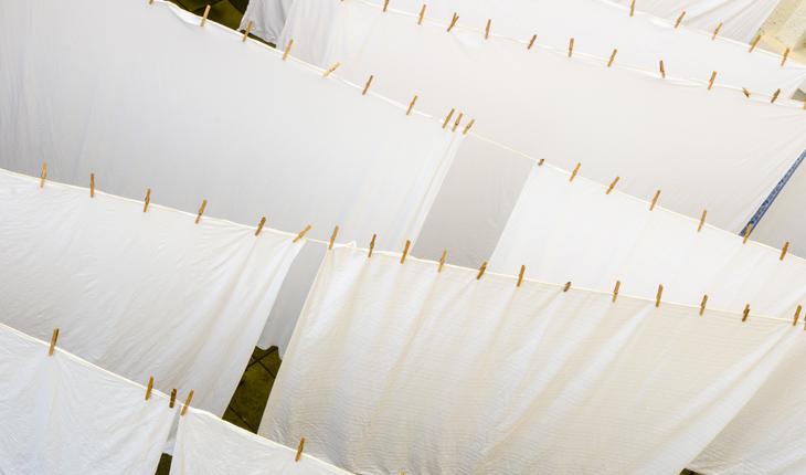 foto de vários lençóis brancos pendurados em varais