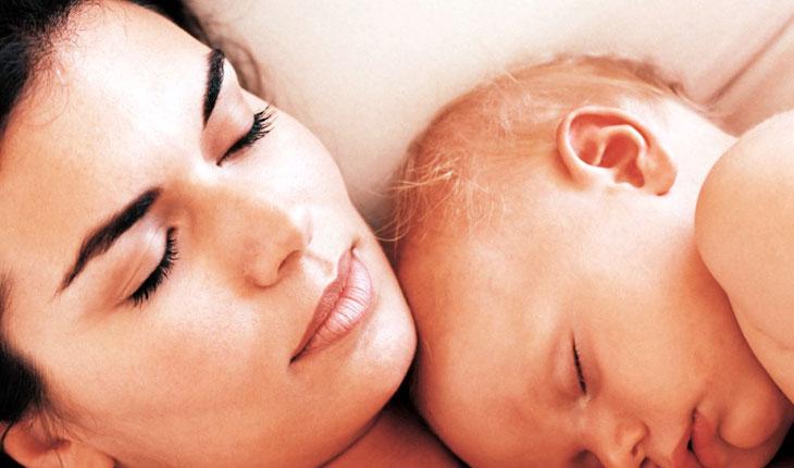 Bebê e mãe com os olhos fechados