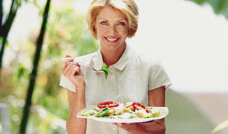 Mulher comendo um prato de salada