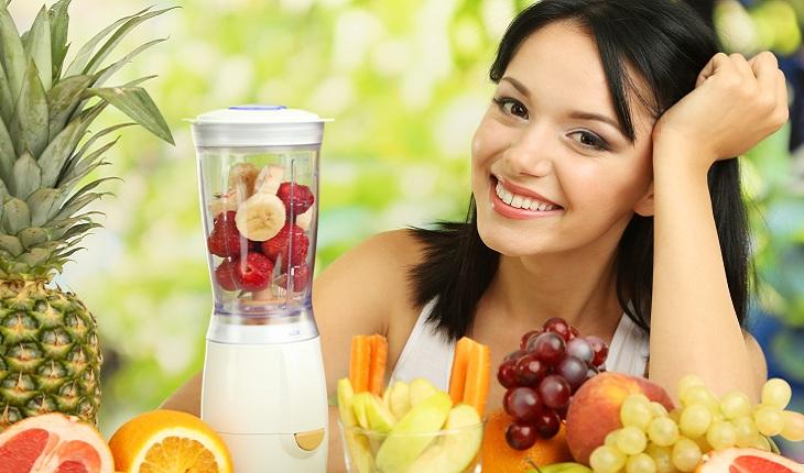 mulher sorrindo ao lado de diversas frutas