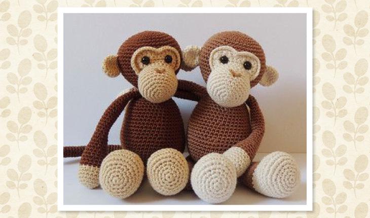 Na foto há duas naninhas em crochê no formato de dois macacos de amigurumi. Eles estão sentados e abraçados.