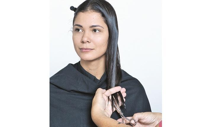 cabeleireiro cortando as pontas dos cabelos de uma mulher