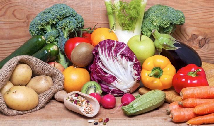 Legumes e verduras em mesa de madeira
