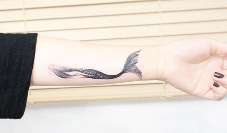 tatuagem de uma sereia nadando em preto e branco
