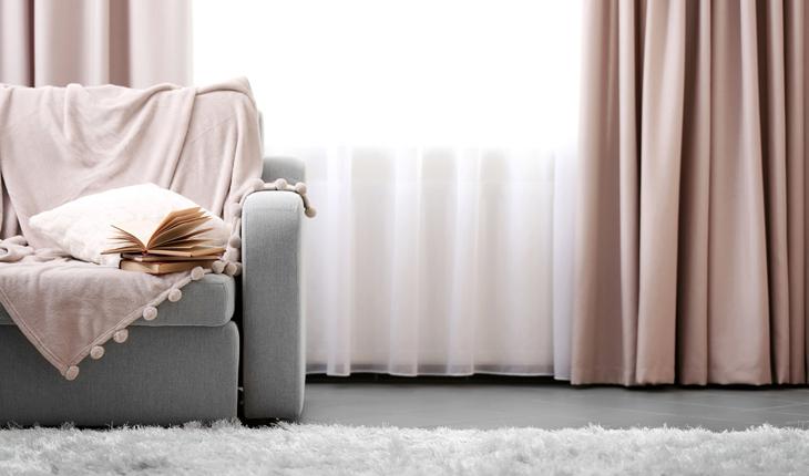 foto de uma sala com sofá cinza e cortina bege