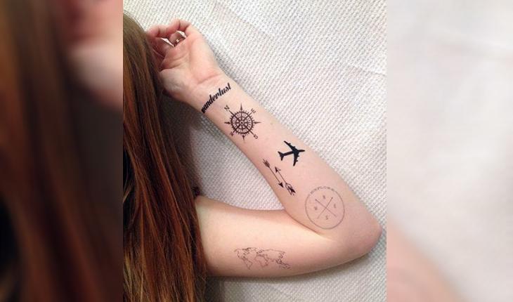 tatuagem de uma rosa dos ventos, um avião, duas flechas, os pontos cardeais e um mapa mundi