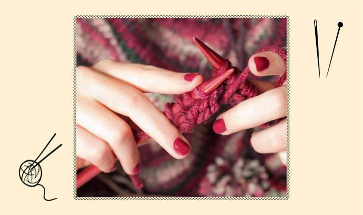 mãos fazendo tricô com lã cor de vinho