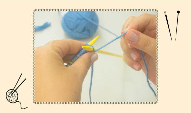 mãos fazendo tricô com linha alzul