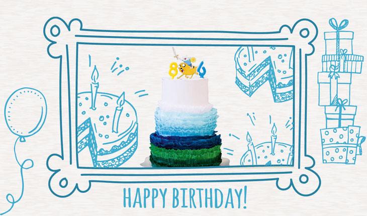 Na imagem há a foto de um bolo decorado nas cores azul e branco. No topo do bolo há uma imagem dos personagens principais da Hora da Aventura. Ao redor da foto do bolo há uma moldura branca com desenhos em azul de temas de festa de aniversário.