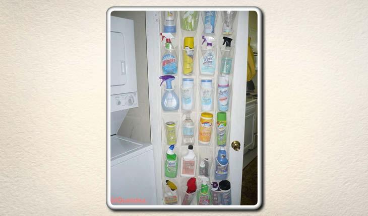 A imagem mostra uma sapateira de porta sendo utilizada para guardar produtos de limpeza na porte de um armário branco.
