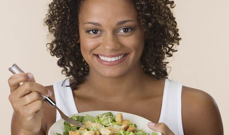 mulher, negra, comendo salada, sorrindo, anti-barriga