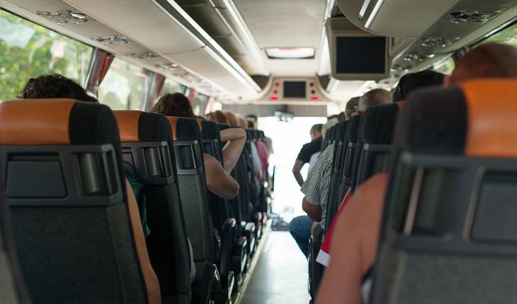 ônibus de excursão com várias pessoas dentro, sentadas
