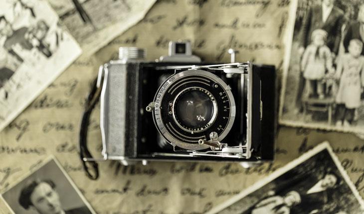 foto de uma câmera antiga sobre uma carta e rodeada por outras fotos
