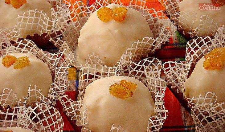 receita de bombom de coco e uva-passa, coberto com chocolate branco e decorado com um pedaço de damasco.