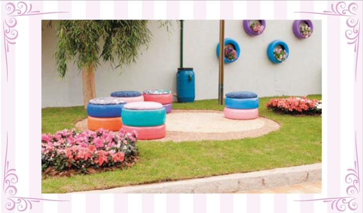 Na imagem há uma foto centralizada de um espaço externo com gramado e flores. Há bancos feitos de pneus coloridos. Ao redor há uma moldura branca com detalhes em rosa.