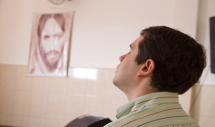 Imaegm de um homem de olhos fechados visto de lado, em sinal de oração. orações de proteção para a família