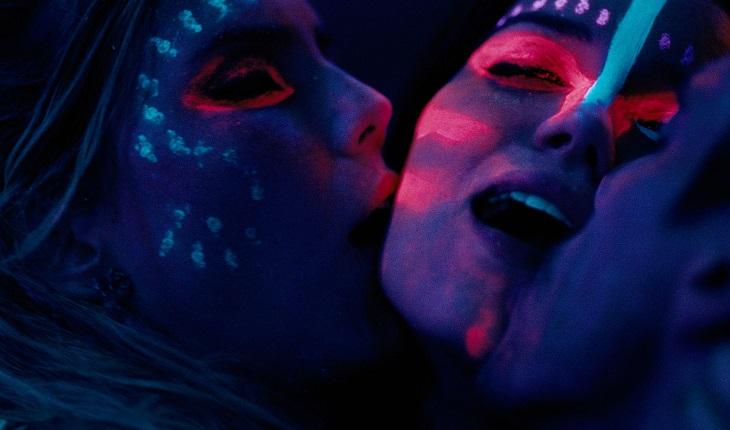 três pessoas se beijando em luz negra com neon em filme brasileiro romântico