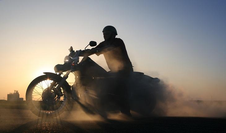imagem de uma moto sendo pilotada em um dia de por do sol - acidente