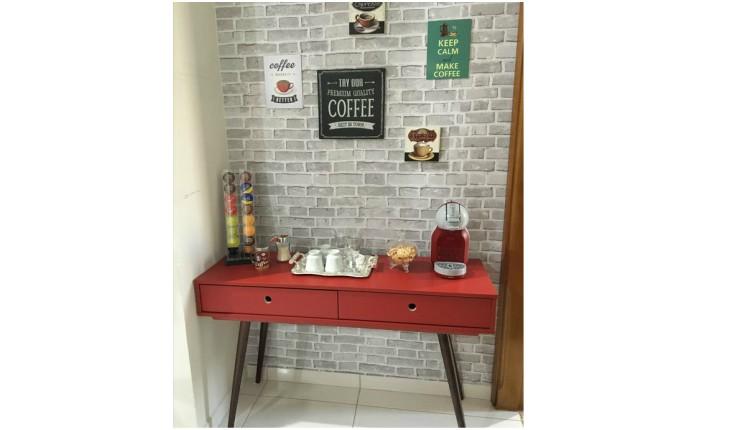 aparador vermelho com pé palito com cafeteira e itens de café