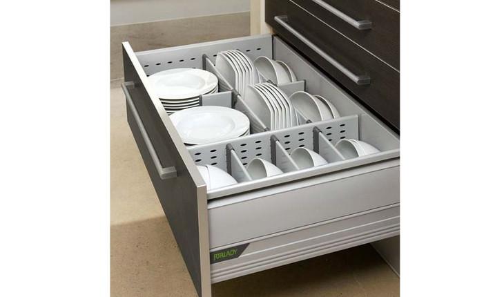 A foto mostra uma gaveta grande e funda que é utilizada para guardar pratos e outros recipientes de cozinha.