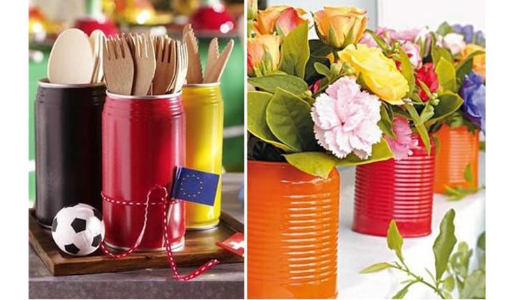 Na foto há duas imagens que mostram latas pintadas de cores vivas. Na primeiras as latas servem de suporte para talheres e na segunda são vasinhos com flores dentro. É uma ideia de decoração com latas para uma festa.