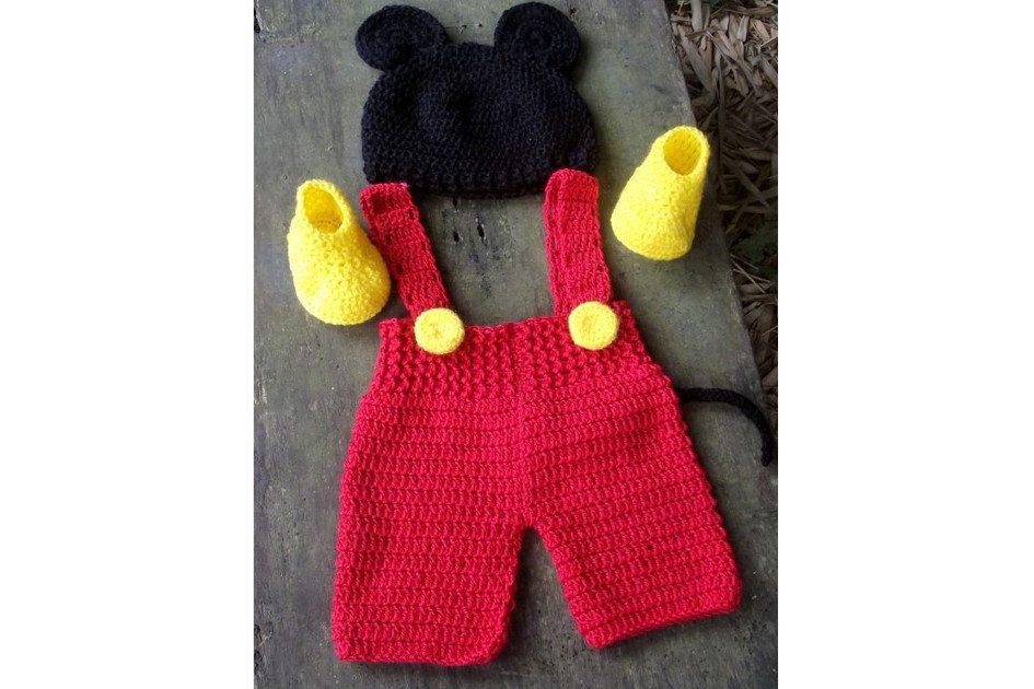 Na foto há uma fantasia do Mickey que é um macacão vermelho, uma touca preta e sapatinhos amarelos. Todas as peças são feitas de crochê.