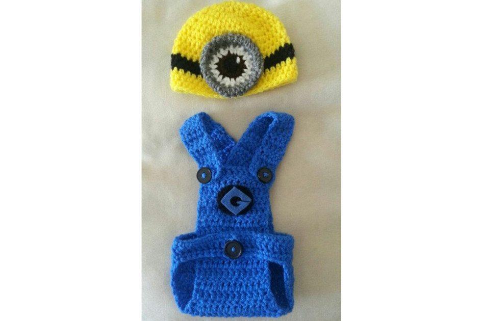 Na foto há uma fantasia de Minion feita de crochê. A roupa é azul e a touca da cabeça é amarela com detalhes em preto e cinza.