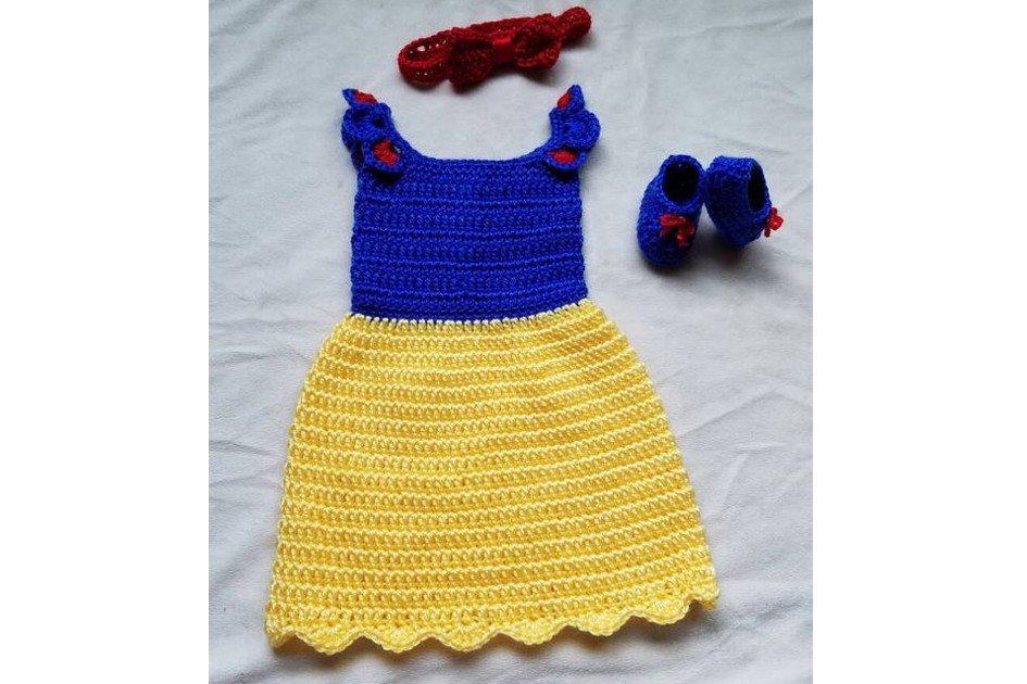 Na foto há uma fantasia da Branca de Neve feita de crochê. A saia é amarela e a parte de cima é azul.
