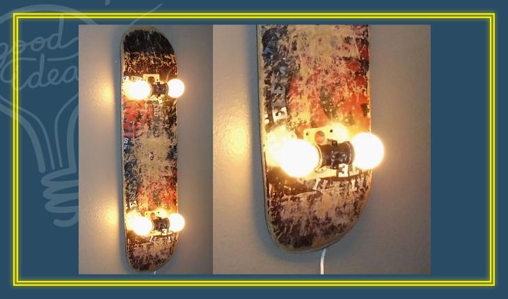A foto mostra um luminária de parede feita com um skate. A lâmpadas foram colocadas nos espaços das rodinhas do skate.