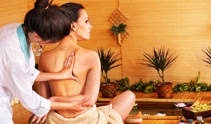 mulher recebendo massagem thai nas costas