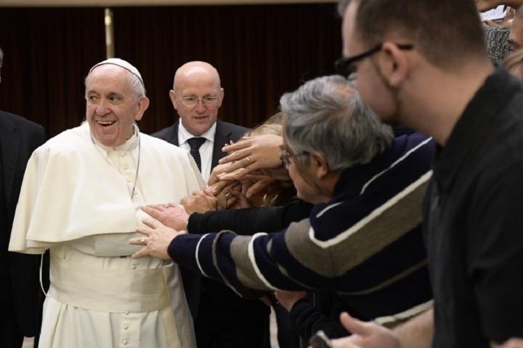 Na imagem, o Papa Francisco está sendo agarrado por muitos fiéis que querem sua atenção, ele sorri achando engraçada a situação. Mensagem de amizade. 