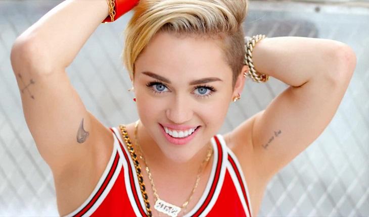 Foto de Miley Cyrus em pose com grades ao fundo