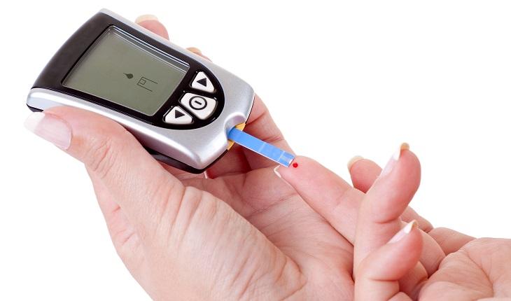 pessoa medindo a glicemia com um aparelho no dedo. Um dos motivos para inserir a batata-doce na dieta é o controle do diabetes.
