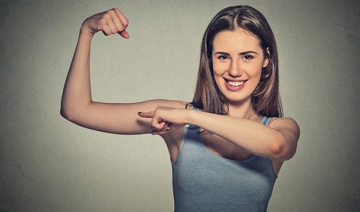 mulher mostrando o músculo do braço. um dos motivos para inserir a batata-doce na dieta é para aumentar a imunidade.