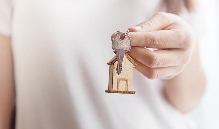 mulher segurando chaveiro de casa com chaves