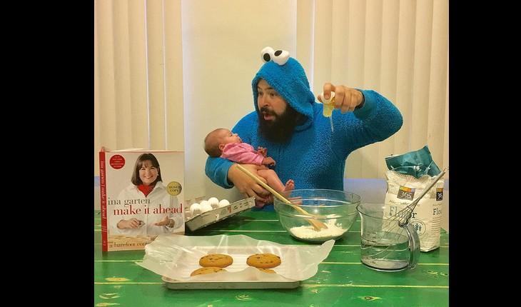 pai e filha fazendo uma fotografia engraçada, com ele vestido de monstro quebrando um ovo e a filha no colo