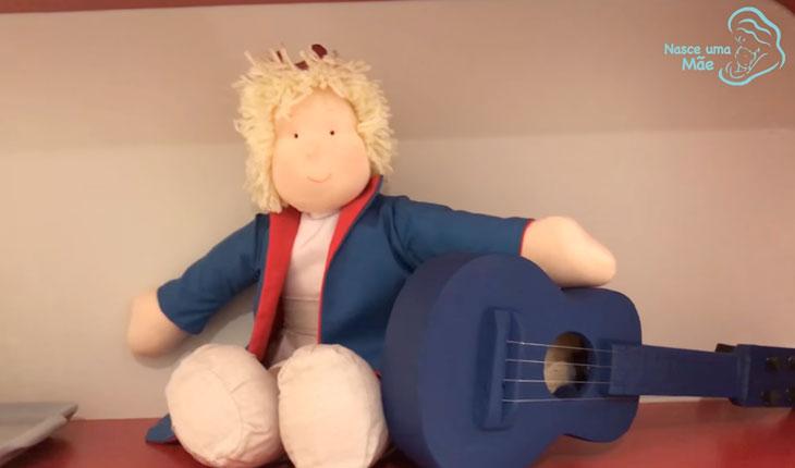 boneco de príncipe segurando um violão