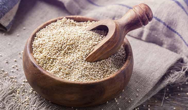 quinoa em uma travessa de madeira com uma colher de madeira