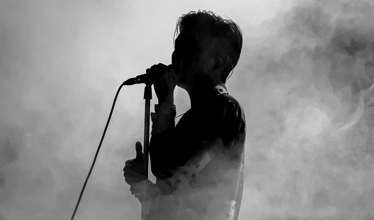 cantor ou vocalista na frente de um microfone, foto em preto e branco