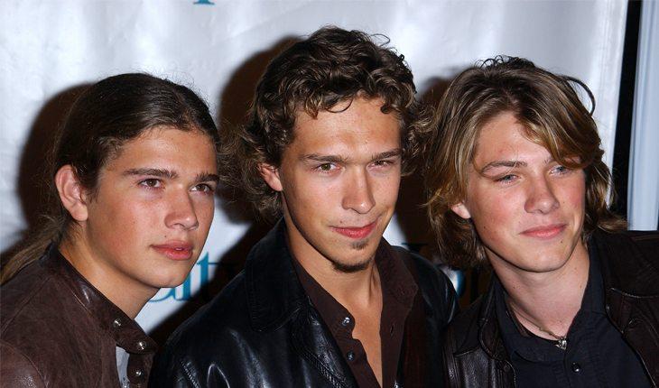 Na foto há os 3 irmãos Hanson em 2003 com os cabelos já mais curtos.