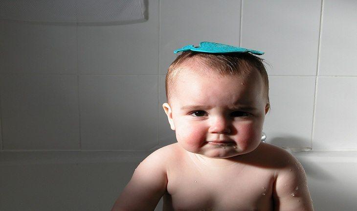 Imagem de um bebê em uma banheira com um brinquedo em sua cabeça em referência aos nomes franceses masculinos.