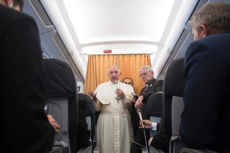 Na imagem, o Papa Francisco está falando ao microfone no avião de imprensa. Batismo dos filhos. 