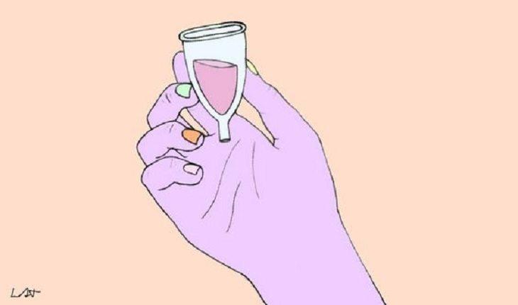 Na imagem, um desenho mostra uma mão segurando um copinho de menstruação com sangue dentro. Dispositivo intrauterino.