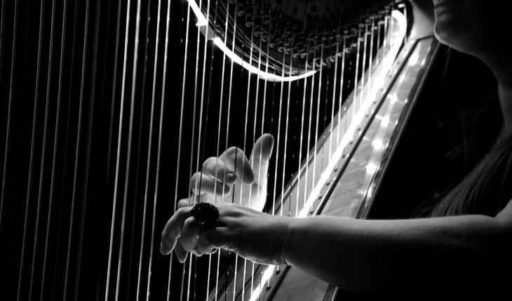 Foto preto e branco de mulher tocando harpa