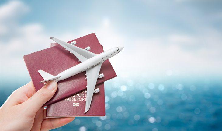 mão segurando passaporte e um avião pequeno
