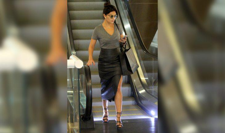 Juliana Paes em shopping usando camiseta de malha cinza e saia de cintura alta preta de couro. Ela está entre as personalidades brasileiras que mais inspiram o streetyle