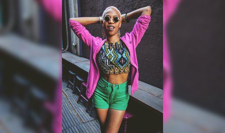 Karol conká usa shorts verde com top estampado e moletom rosa. Ela está entre as personalidades brasileiras que mais inspiram o streetyle